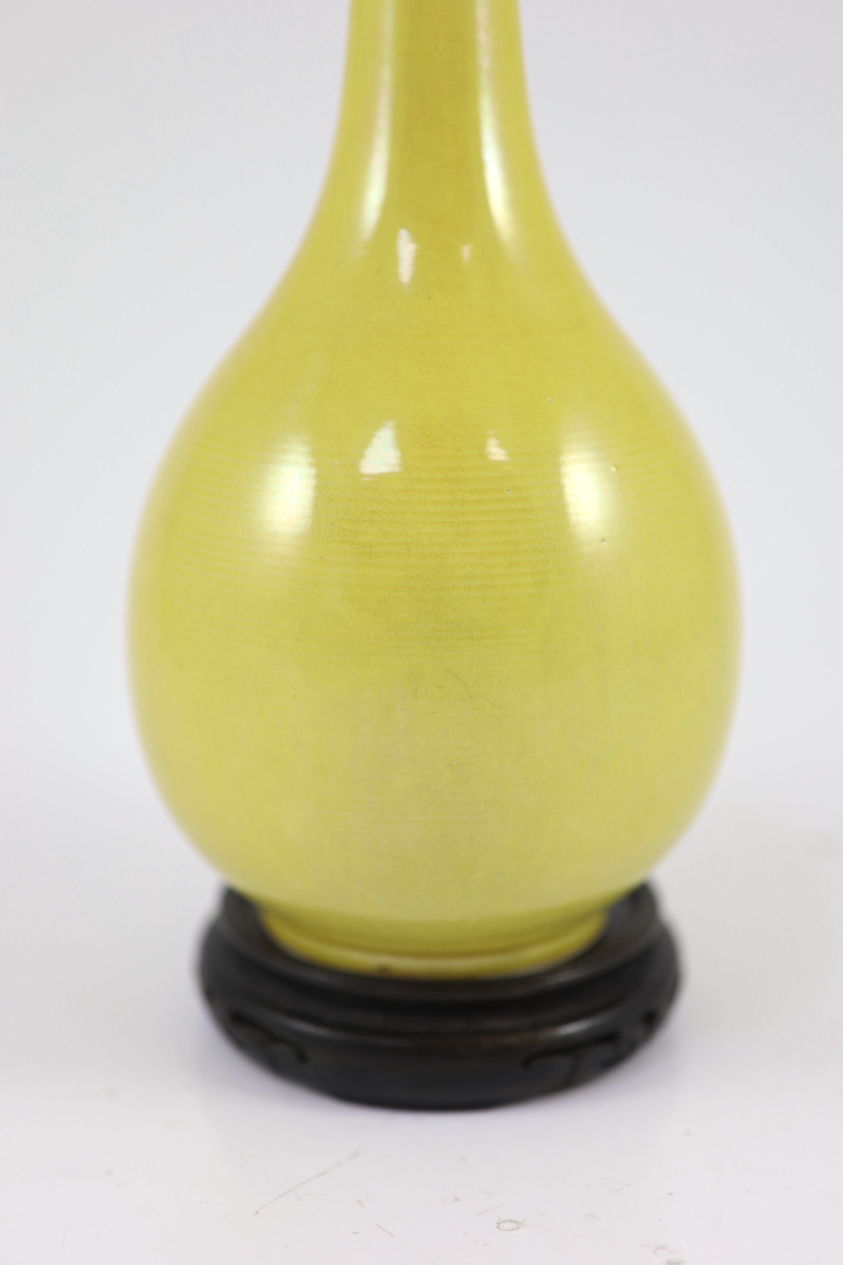 A Chinese yellow ground narrow neck bottle vase, Yongzheng mark but mid 20th century, 24.5cm high, wood stand